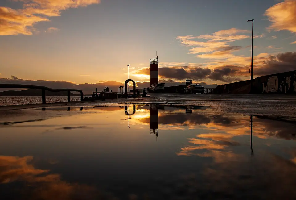 Buncrana pier during sunset with rainwater reflections.
