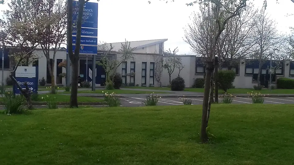Building. Lawn. Trees. Signs. School.