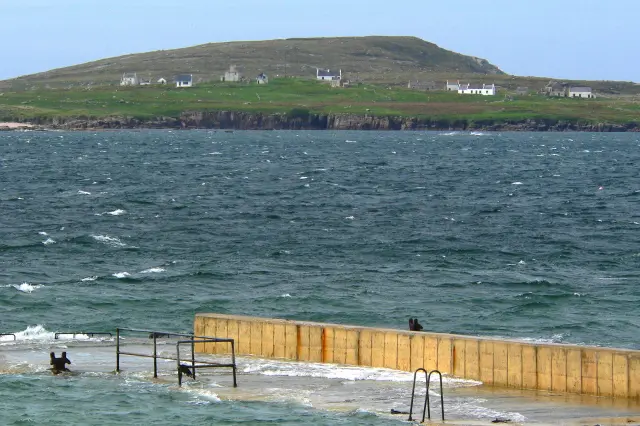 Derrybeg - Pier on Gweedore Bay Shown across Gweedore Bay looking west is Gola Island. Looks like high tide and wind driven choppy water.