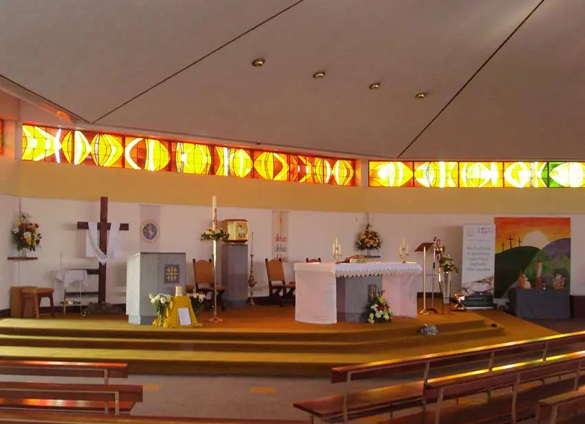 The main Altar and some of the stained glass in the Church of Our Lady Assumed into Heaven in Doonbeg, County Clare, Ireland