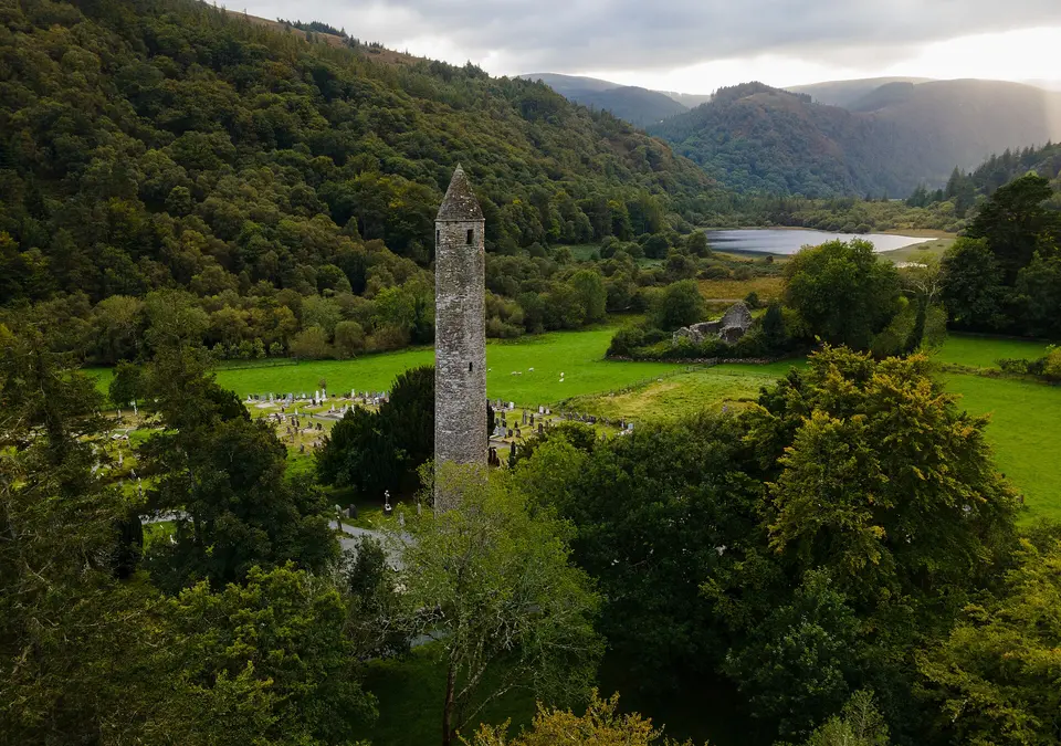 Glendalough Round Tower above the wooded valley and lake