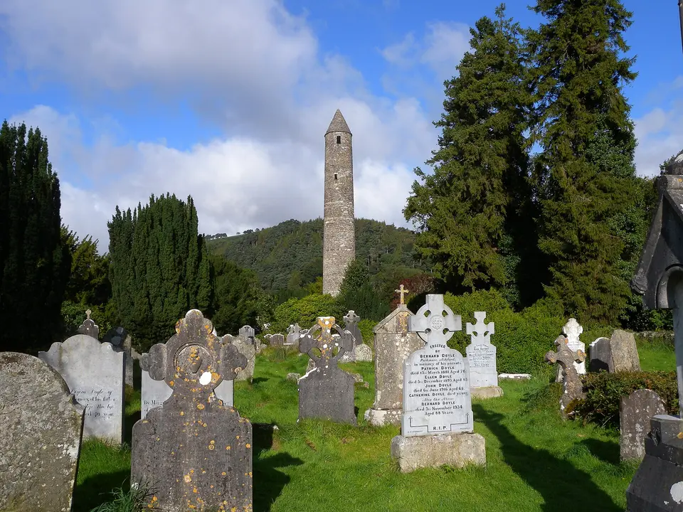 Gravestones at Glendalough, Glendalough round tower in the background