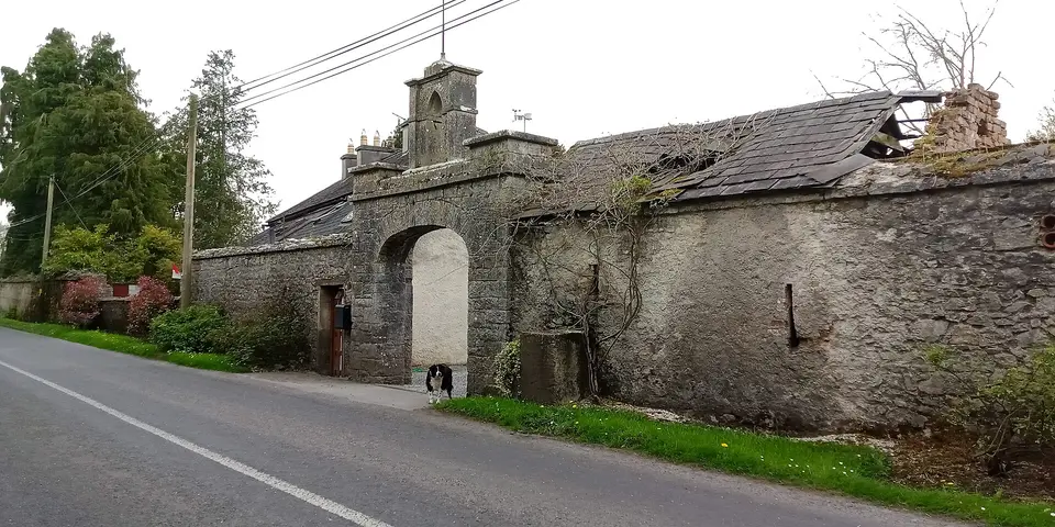 Second of two milk churn stands in Kilcooleyabbey with a beautiful gate in the background, possible leading to one of the lodges into the Kilcooley Estate. close-up