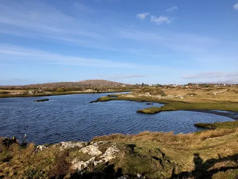 Loch an Taosca i mbaile fearainn Charna; Cnoc an Choillín amuigh thall