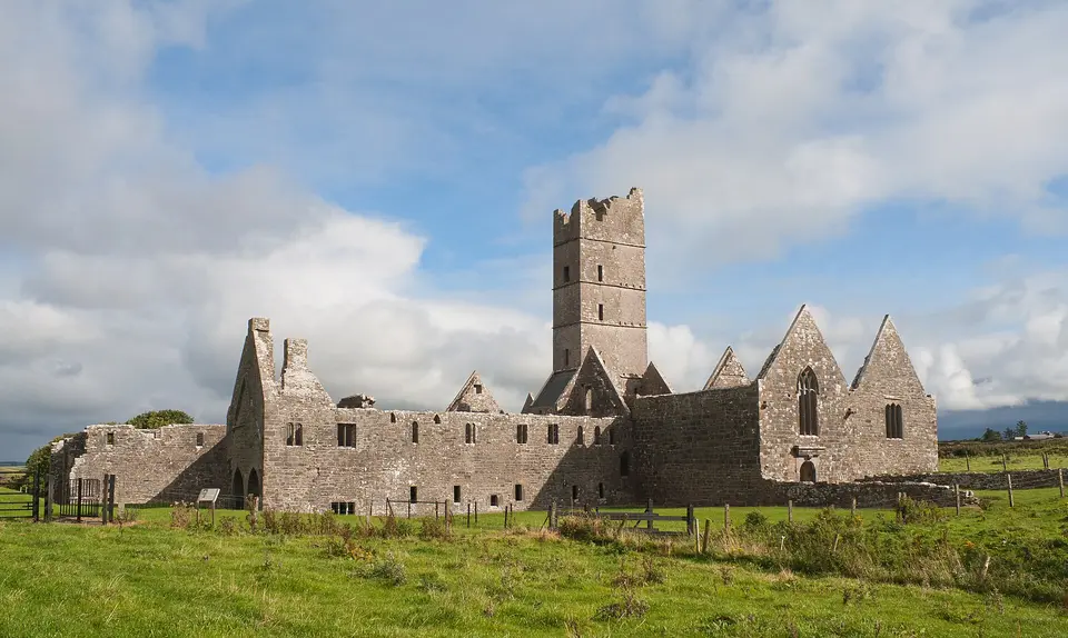 West range of Moyne Friary with domestic buildings on the left, the tower, the nave, and an attached chapel or south aisle with its own gable.