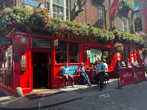 The red facade and hanging flowers of The Temple Bar.