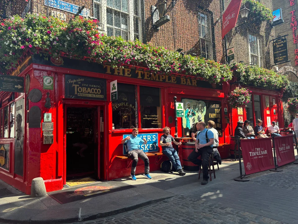 The red facade and hanging flowers of The Temple Bar.
