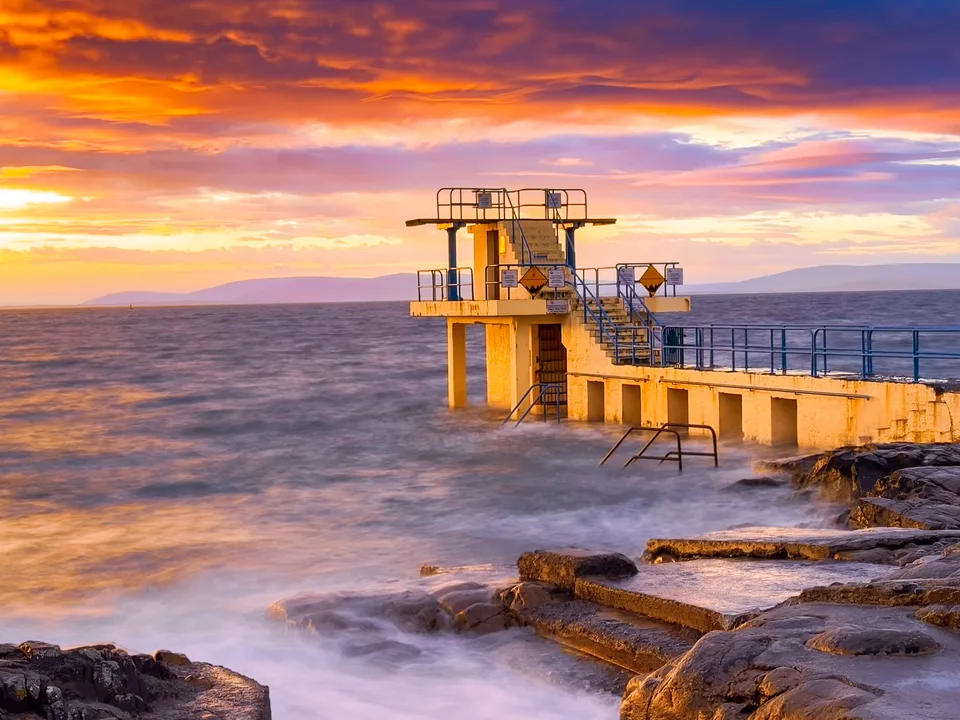 Blackrock Diving Tower at Salthill, with the bay beneath a glowing sky.