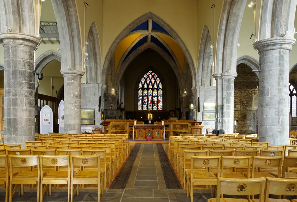 Stone arches and stained glass inside St Nicholas' Collegiate Church.