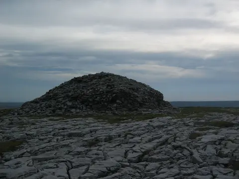 On top of the Turlough Hill / County Clare in Ireland (alt. 925 ft) facing the raided cairn (view WNW). In the foreground the typical 'limestone pavement' of the Burren area.