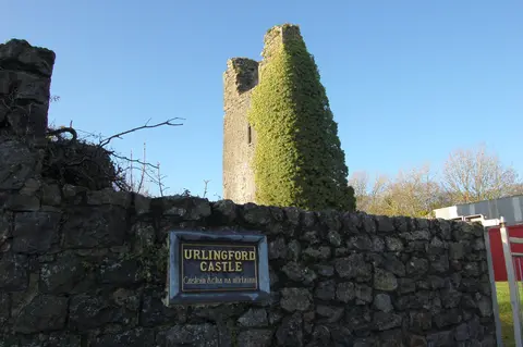 Ruin of the towerhouse castle in Urlingford with the sign in English and Irish