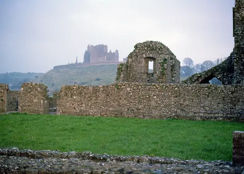 Rock of Cashel, with Hore Abbey in foreground. Photo by Peter Potter, sunset of October 31, 1987.